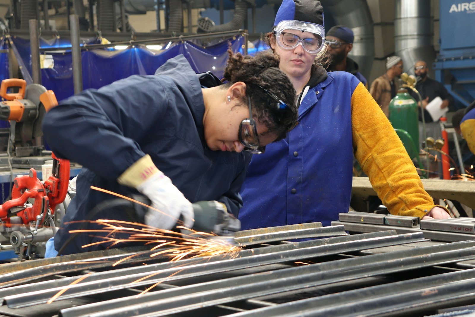 Instructor guiding a trainee on the shop floor